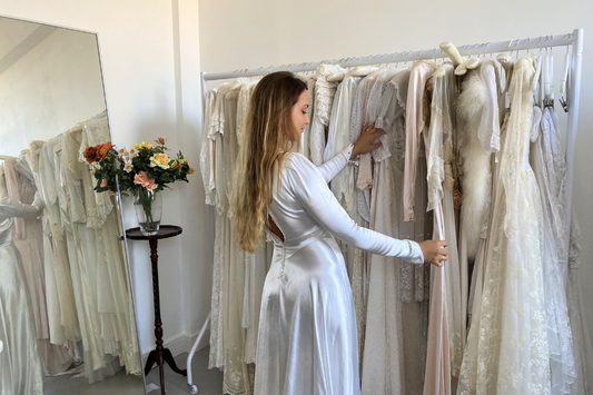 A woman browsing vintage wedding dresses in Adored Bridal Studio